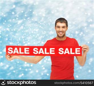 shopping, gifts, christmas, x-mas concept - smiling man in red shirt with sale sign