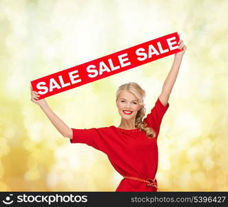 shopping, gifts, christmas, x-mas concept - smiling woman in dress with red sale sign