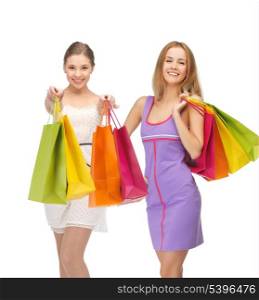 shopping, presents and gifts - attractive girls holding color shopping bags