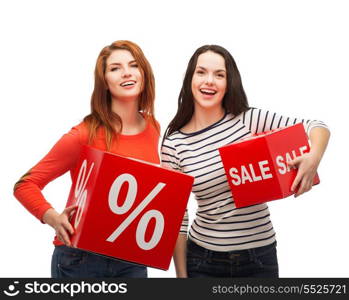 shopping, sale, and gift sconcept - two smiling teenage girls with percent and sale sign on red box