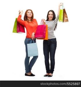 shopping, sale and gifts concept - two smiling teenage girls with shopping bags