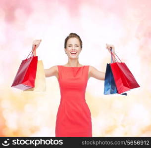 shopping, sale, christmas and holiday concept - laughing elegant woman in red dress with shopping bags