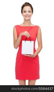 shopping, sale, christmas and holiday concept - smiling elegant woman in red dress with small shopping bag
