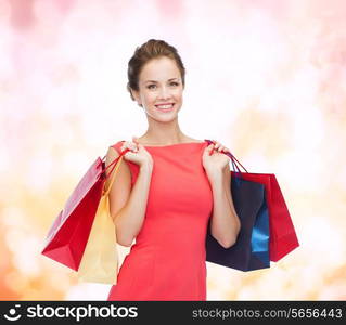 shopping, sale, christmas and holiday concept - smiling elegant woman in red dress with shopping bags