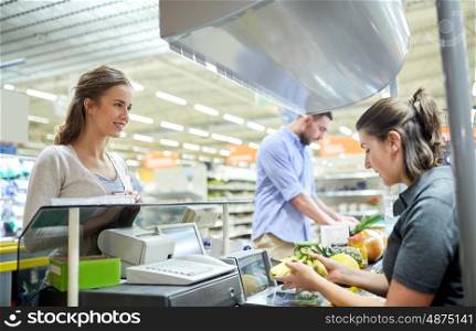 shopping, sale, consumerism and people concept - happy couple buying food at grocery store or supermarket cash register