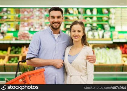 shopping, sale, consumerism and people concept - happy couple with food basket at grocery store or supermarket