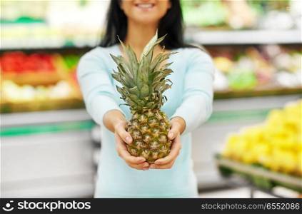 shopping, sale, food, consumerism and people concept - happy woman with pineapple at grocery store. woman with pineapple at grocery store. woman with pineapple at grocery store