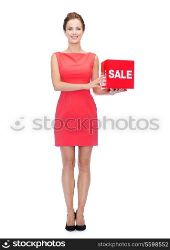 shopping, sale, gifts, christmas and holidays concept - smiling woman in red dress with sale sign