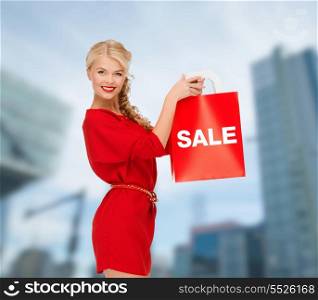 shopping, sale, gifts, christmas and x-mas concept - smiling woman in red dress with shopping bags outdoors