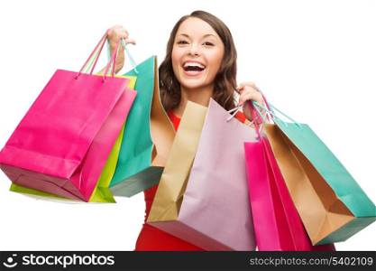 shopping, sale, gifts, christmas, x-mas concept - smiling woman in red dress with colorful shopping bags