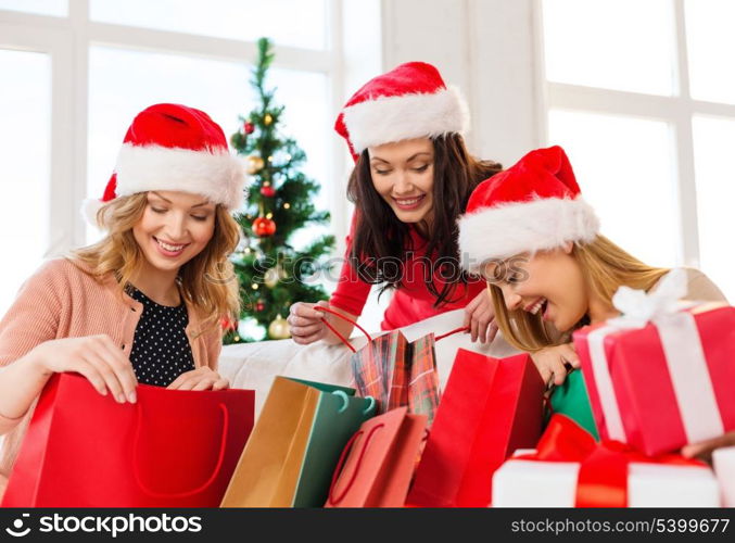 shopping, sale, gifts, christmas, x-mas concept - smiling women in santa helper hats with shopping bags and many gift boxes