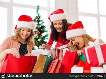 shopping, sale, gifts, christmas, x-mas concept - smiling women in santa helper hats with shopping bags and many gift boxes