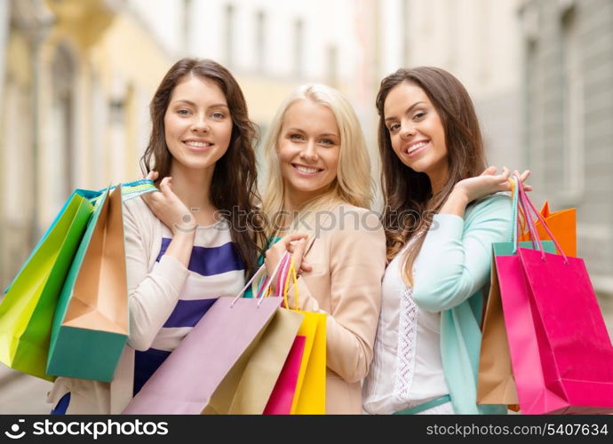 shopping, sale, happy people and tourism concept - beautiful girls with shopping bags in ctiy