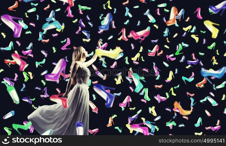 Shopping therapy. Young woman in white dress and many falling shoes