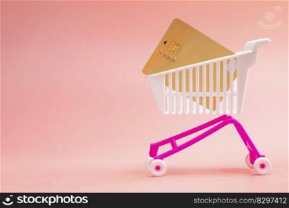 Shopping trolley cart with credit card on pink background. concept for shopping online. delivery, supermarket, paying with credit card, space for text. Shopping trolley cart with credit card on pink background. concept for shopping online. delivery, supermarket, paying with credit card,