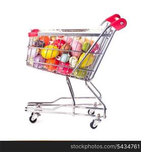 Shopping trolley with many decorative easter eggs on white