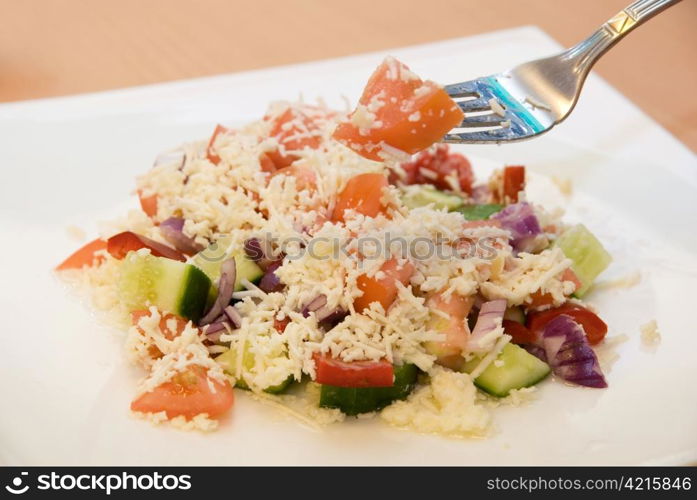 Shopski salad closeup of tomato, cucumber, pepper, sheep cheese, olive oil and greens