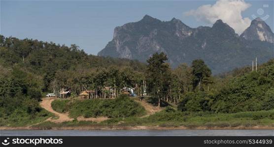 Shoreline village with rocky mountains in background, River Mekong, Pak Ou District, Luang Prabang, Laos