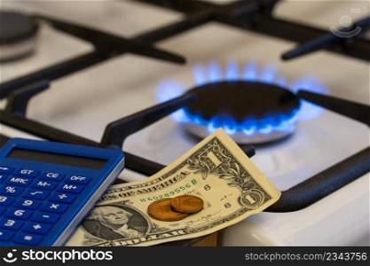 Shortage and gas crisis. Money and a calculator on the background of a burning  gas stove. gas burner, shortage