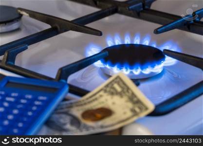 Shortage and gas crisis. Money and a calculator on the background of a burning  gas stove. gas burner, shortage