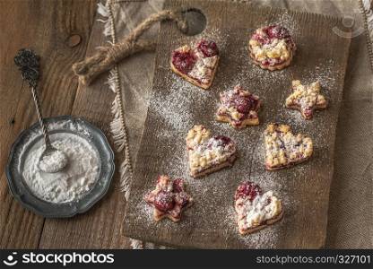 Shortbread biscuits with cherry filling on the wooden board