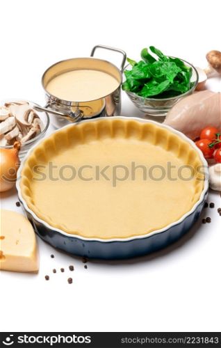 shortbread dough for baking quiche tart and ingredients in ceramic baking form. shortbread dough for baking quiche tart and ingredients in baking form
