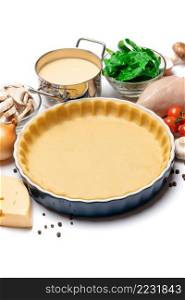 shortbread dough for baking quiche tart and ingredients in ceramic baking form. shortbread dough for baking quiche tart and ingredients in baking form