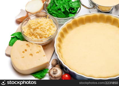 shortbread dough for baking quiche tart in ceramic baking form and ingredients. shortbread dough for baking quiche tart in baking form and ingredients