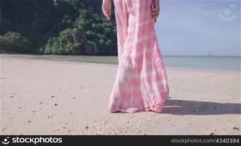 Shot from behind of female walking on the island beach, small calm waves, fresh air environment, Hot sunny weather, clear sky seascape, Freedom life escape from city, island summer vacation tourist