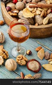 Shot glass with aromatic alcohol from nuts.Nut liquor.Tincture on nuts.Nut flavoring. Tasty nut tincture