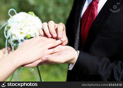 Shot moment when the groom puts the ring on a young bride&#39;s hand.