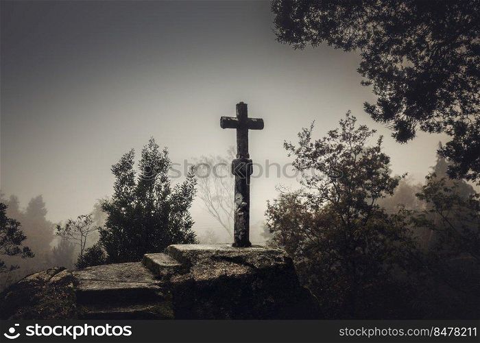 Shot of a beautiful religious stone cross on a foggy day