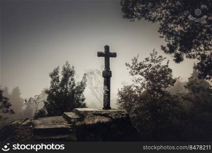 Shot of a beautiful religious stone cross on a foggy day