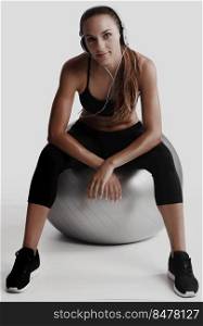 Shot of a beautiful young woman sitting on swiss ball after the train