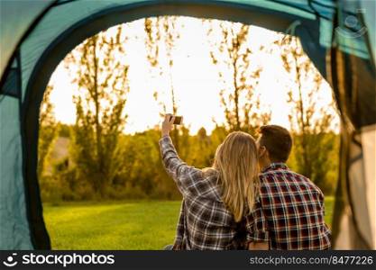 Shot of a happy couple c&ing on the nature and making a selfie