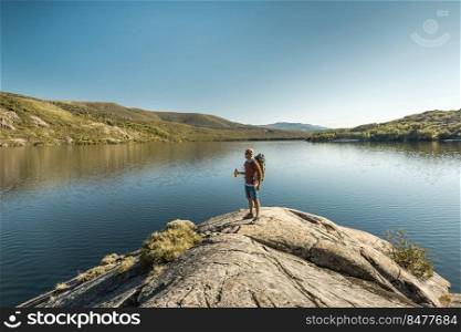 Shot of a man hiking near a beautiful lake