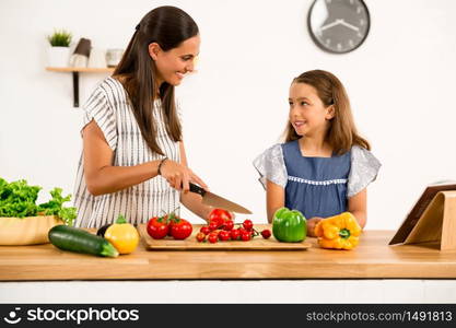 Shot of a mother and daughter having fun in the kitchen