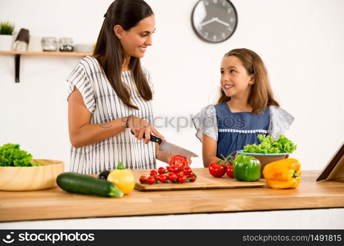 Shot of a mother and daughter having fun in the kitchen