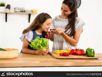 Shot of a mother and daughter having fun in the kitchen