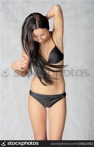Shot of a sexy woman in black lingerie over grey background.