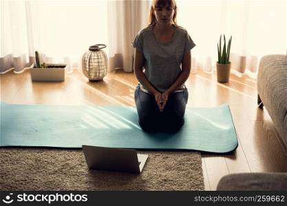 Shot of a woman at home, ready for follow your online class of yoga