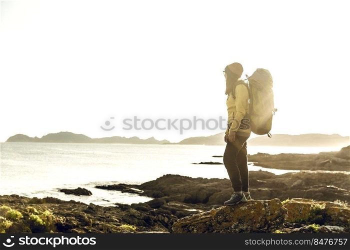 Shot of a woman exploring the coastline with backpack