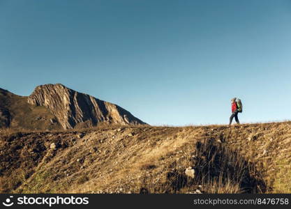 Shot of a woman exploring the montains with a backpack