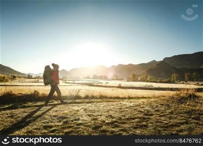 Shot of a woman walking with a backpack at sunrise