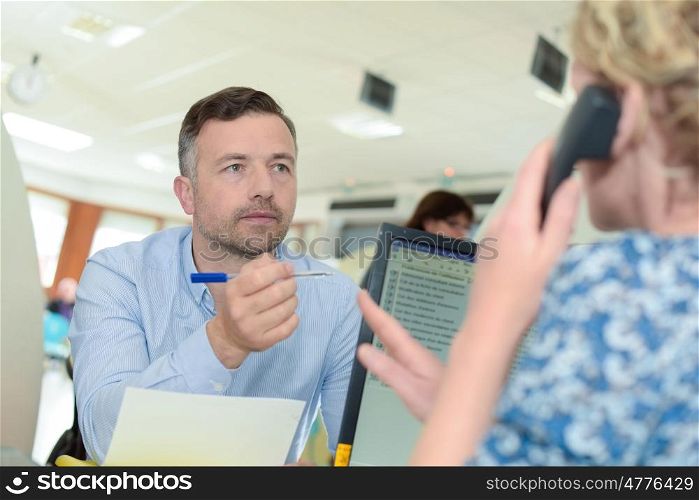 shot of a young businessman talking with female colleague