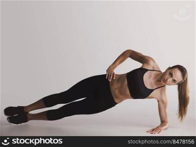Shot of a young woman doing side plank exercises 