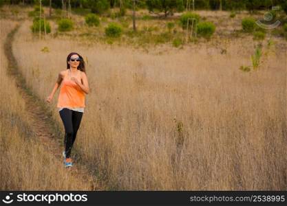 Shot of an attractive woman running outdoor on a meadow