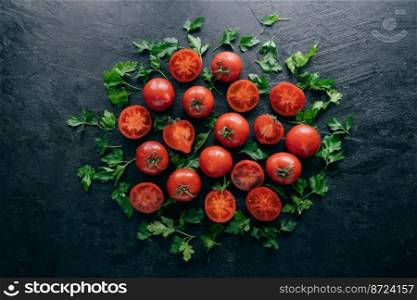 Shot of red ripe tomatoes and green fresh parsley on dark background. Vegetable composition. Healthy nutrition concept. Organic food