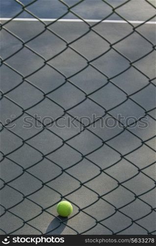 Shot of tennis ball lying on ground in front of net