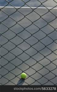Shot of tennis ball lying on ground in front of net